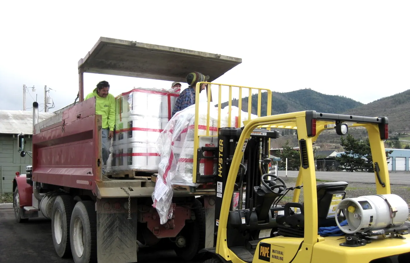 Forklift unloading a flatbed of pallets at Rogue Farmers — Southern Oregon